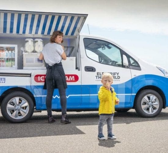 child eating ice cream next to white ice cream van
